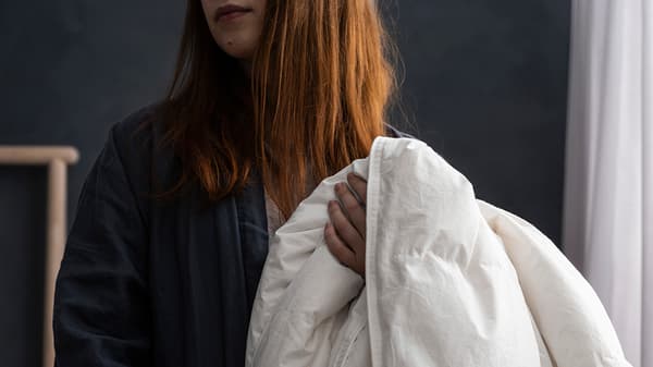A woman holding a white duvet