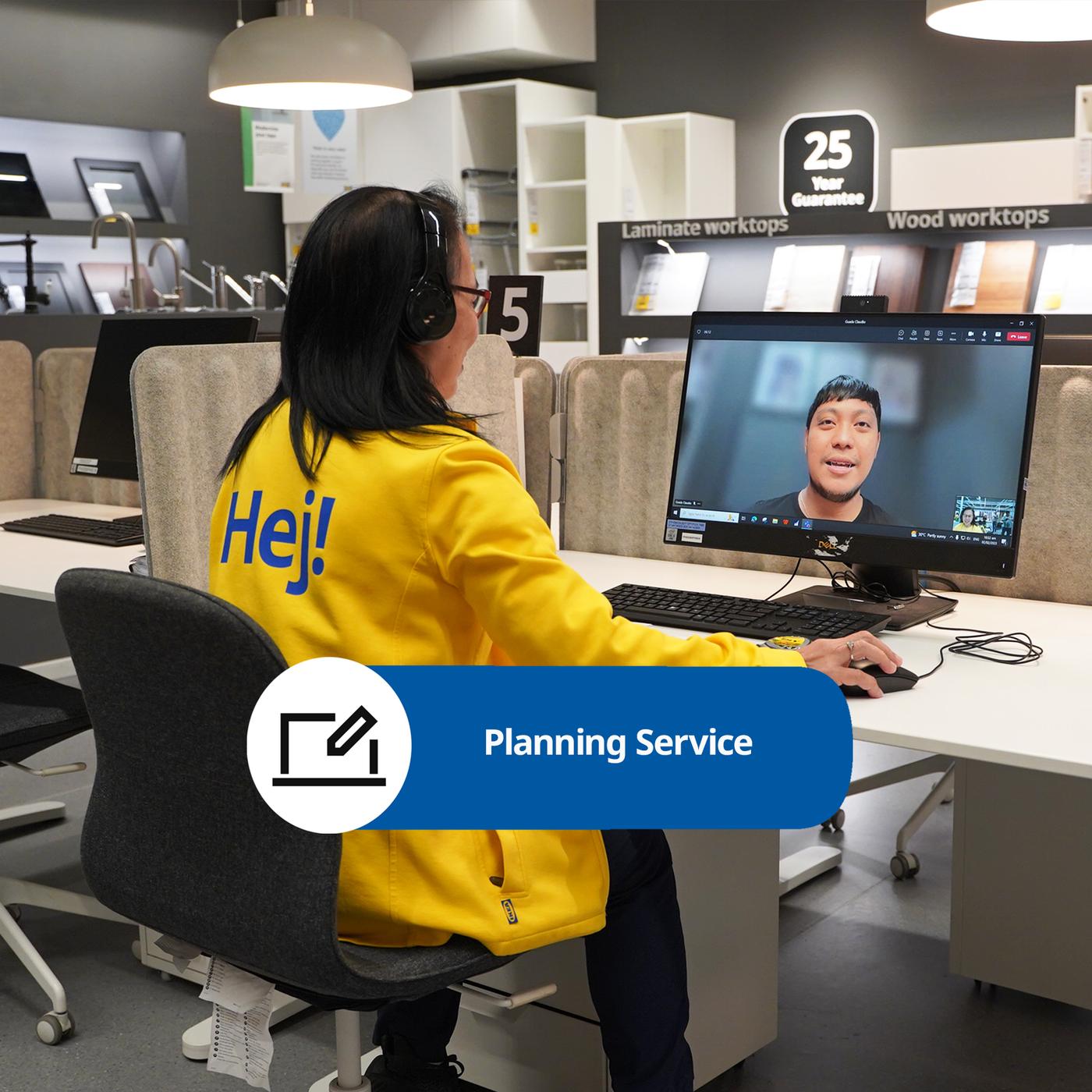 A woman in a bright yellow jacket sits at a desk with a computer, engaged in a virtual planning service, surrounded by display cabinets.