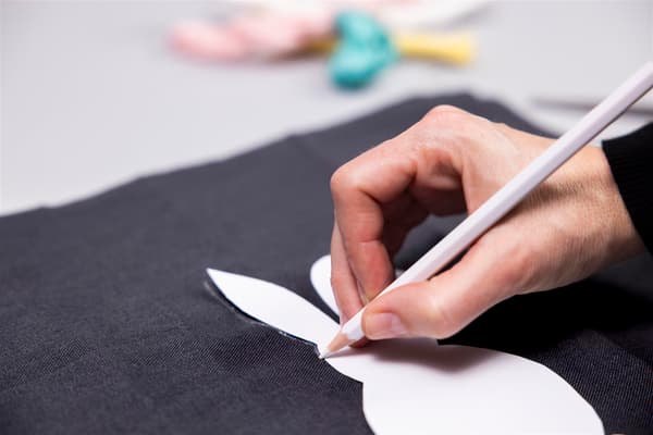 A woman is drawing a rabbit on a black 