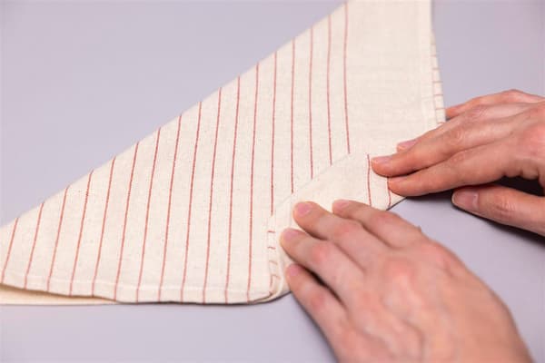 A woman is folding a napkin