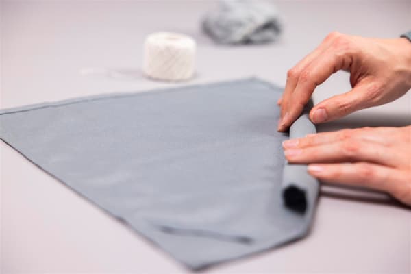 A woman is rolling up a napkin.