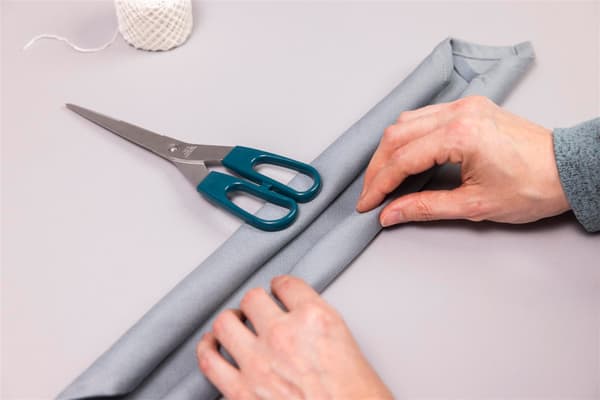 A woman is rolling up a napkin.