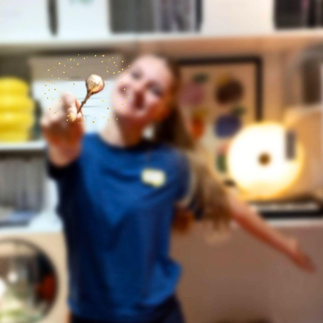 A woman is standing with a lolly in her hand. The caption ‘Find the golden lolly!’ appears below her. 