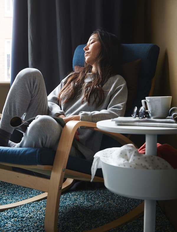 A woman leaning back into an armchair.