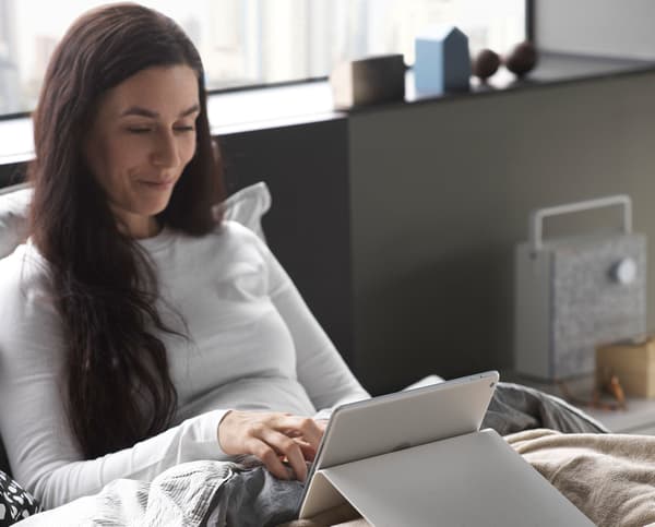 A woman on a mobile device in bed.