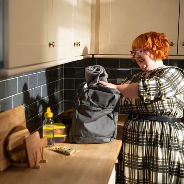A woman packing her backpack for an outdoor trip