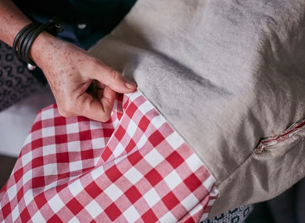 A woman sews a holiday gift bag.