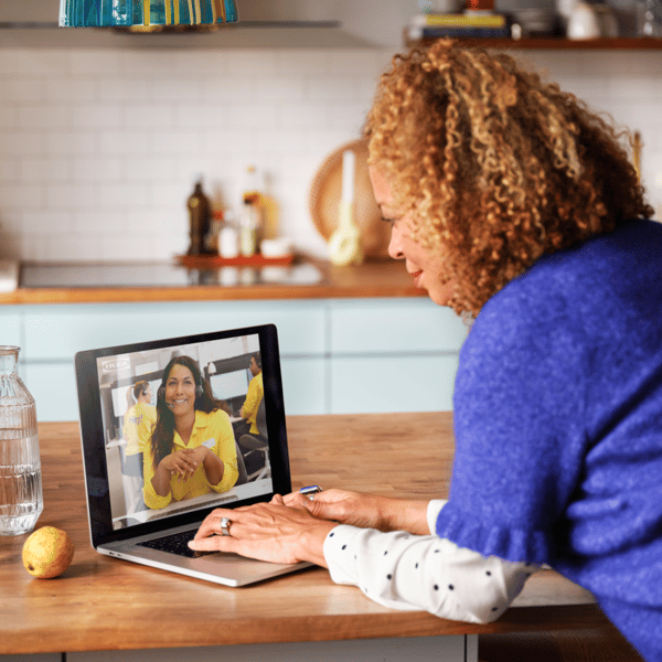 A woman sits in her kitchen and video calls an IKEA employee
