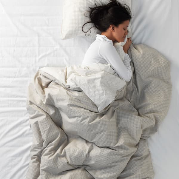 A woman sleeping in the foetal position.