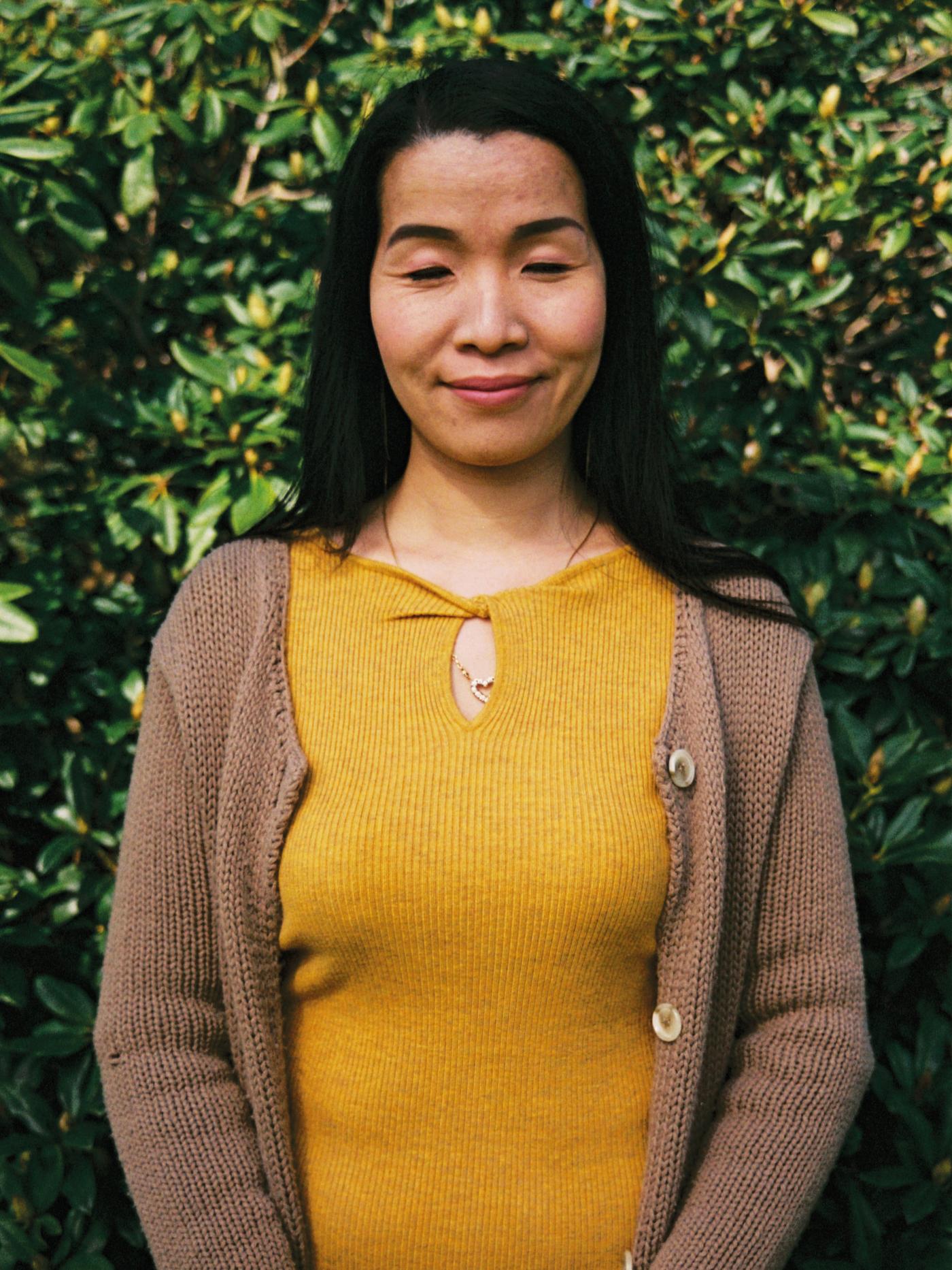 A woman wearing a yellow shirt smiling representing IKEA for the World Refugee Day campaign.