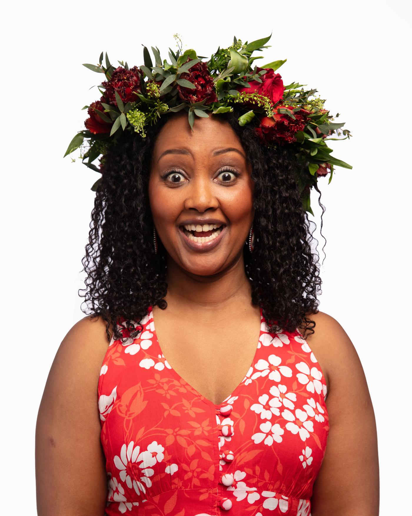 A woman with a flower crown and a red dress smiles
