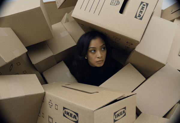 A women is stuck in the middle of a pile of IKEA moving boxes