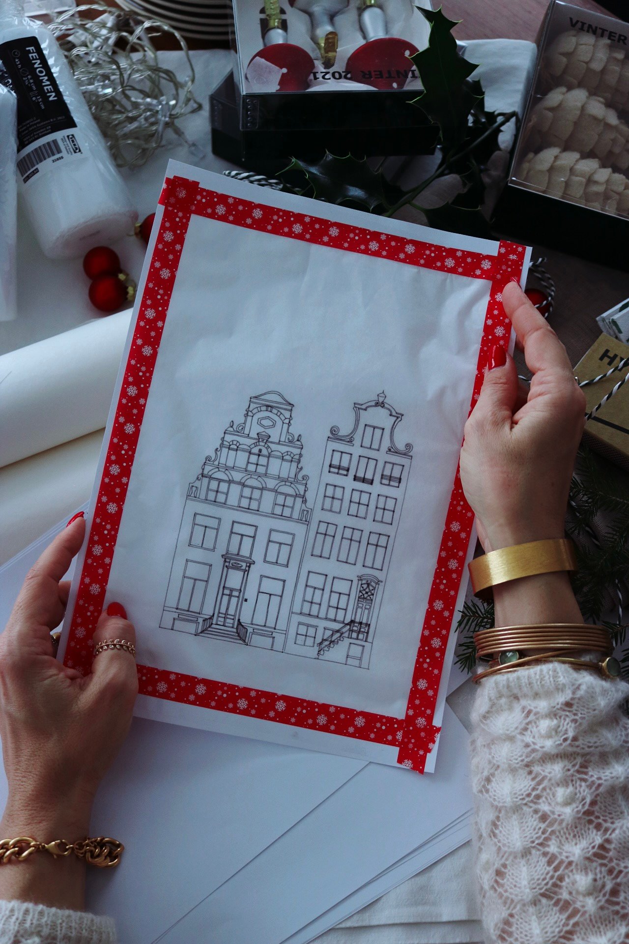 A womens hands holding a print with houses on it