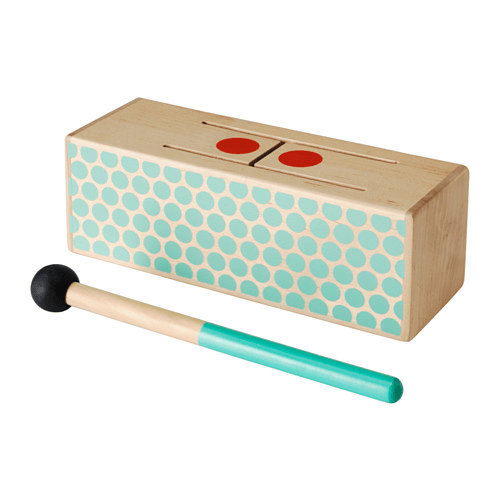 A wooden block toy drum with a drumstick against a white background.