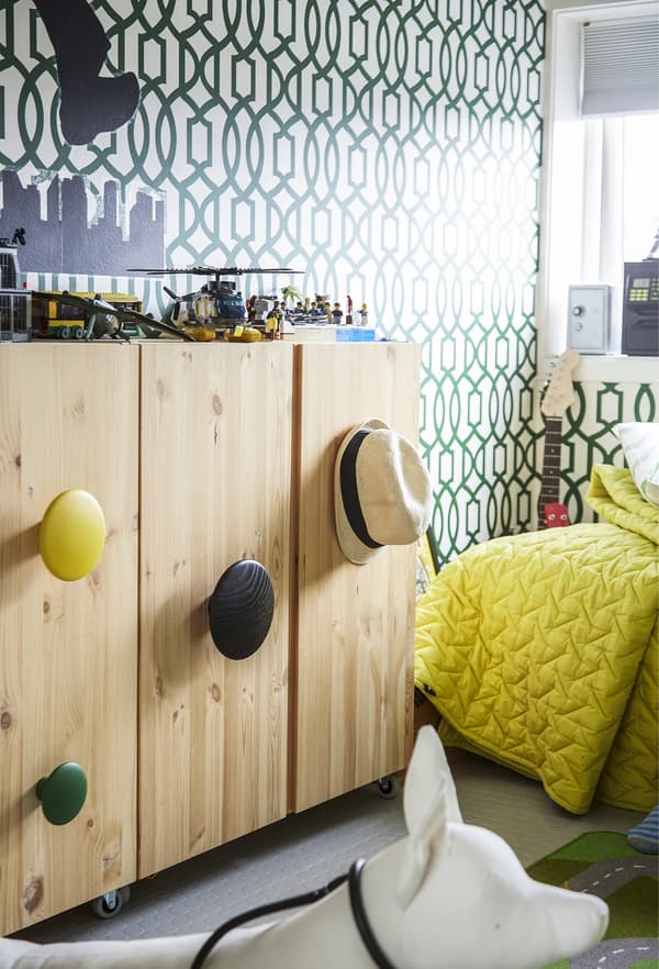 A wooden cabinet with colourful handles.
