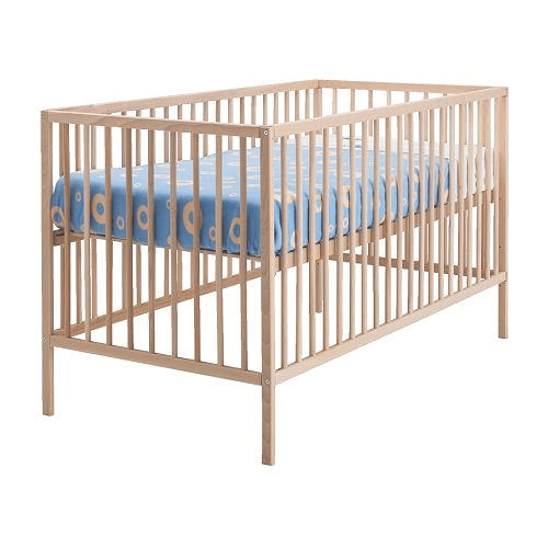 A wooden crib with a mattress against a white background.