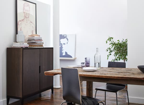 A wooden dining table and brown cabinet in a dining area.