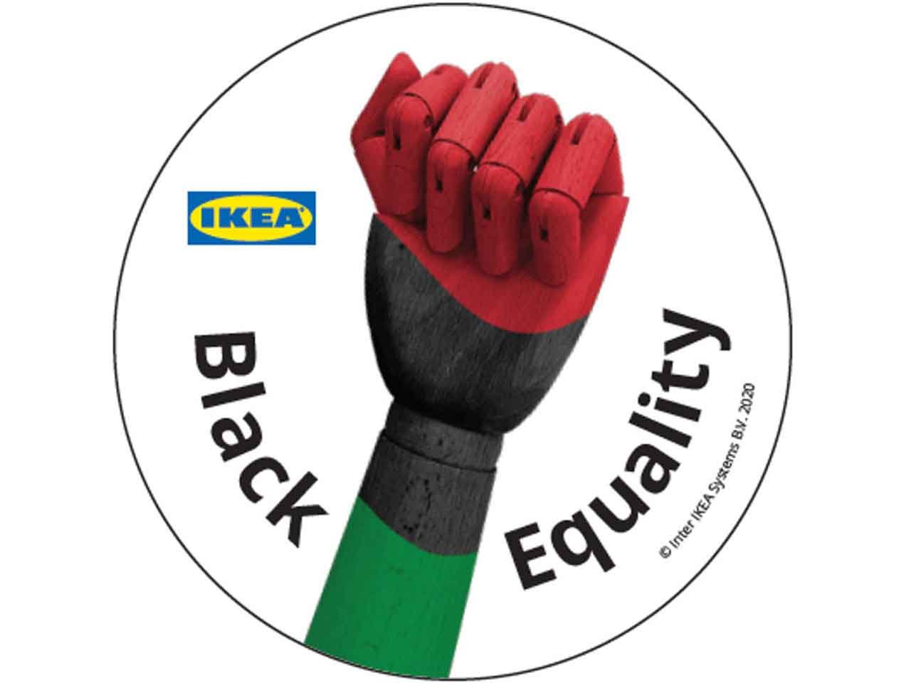 A wooden fist painted green, black and red with the words Black Equality and the IKEA logo within a circle.