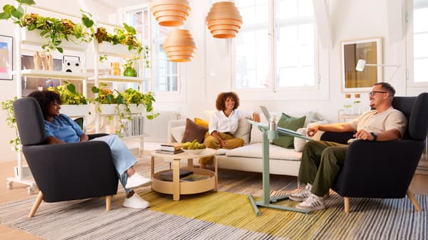 A work breakroom consisting of IKEA products, a few co-workers enjoying their break on soft seating.
