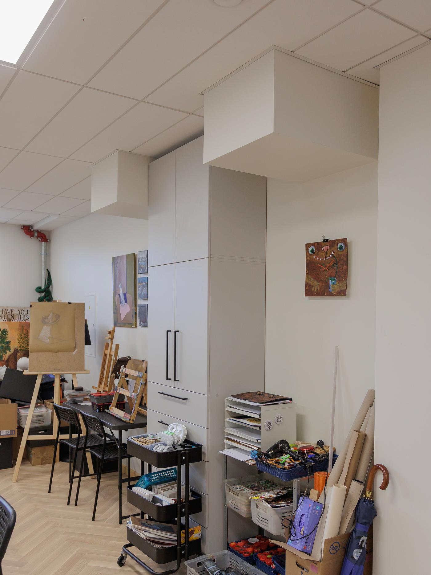 A workspace filled with scattered art supplies and materials needing organisation.