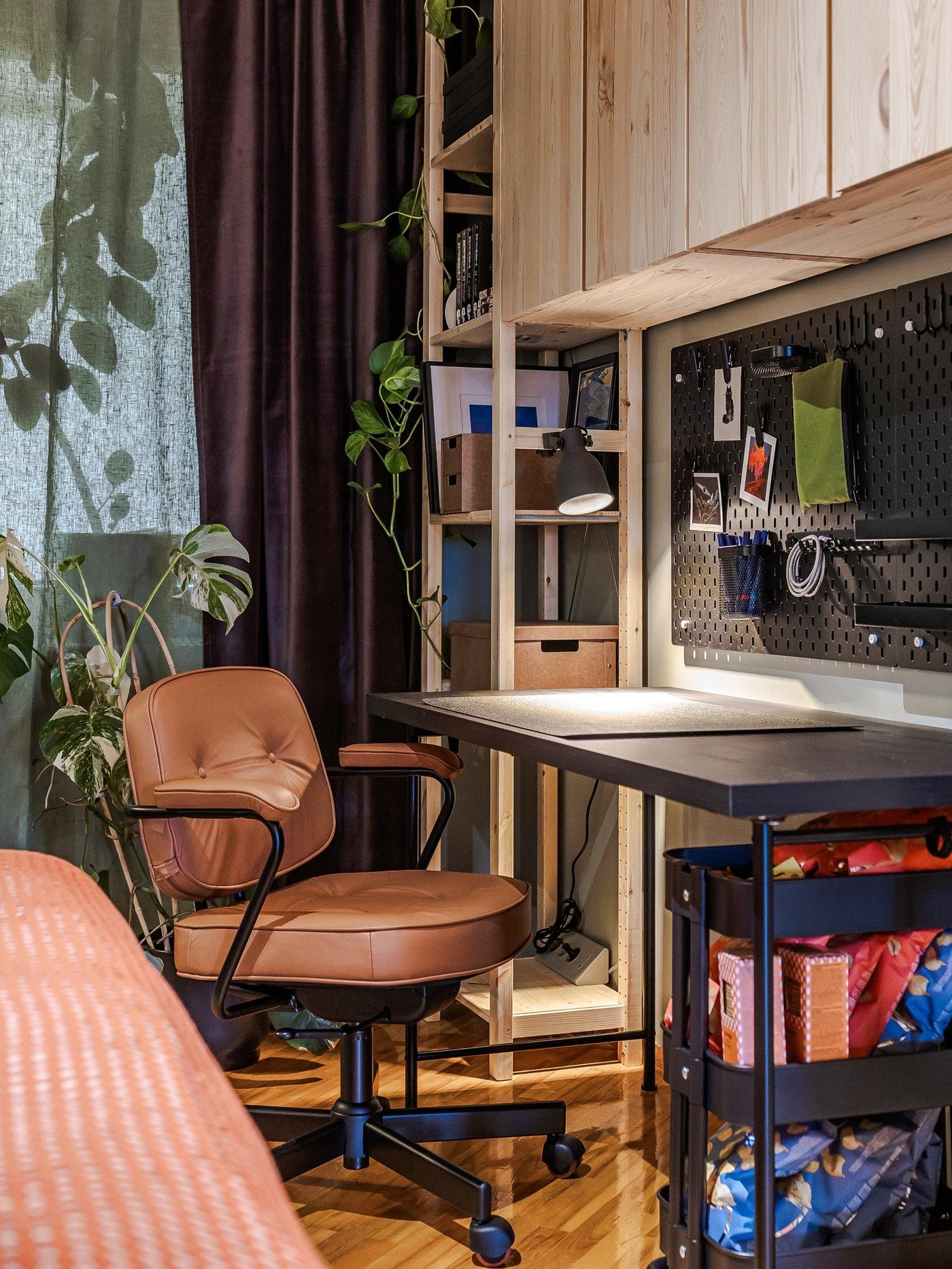 A workspace in the bedroom with a desk, shelving and cabinets in natural wood.