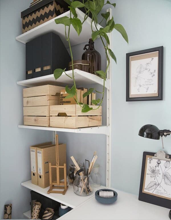 A workspace under the staircase with wall shelves filled with crated and boxes holding personal and office stuff.