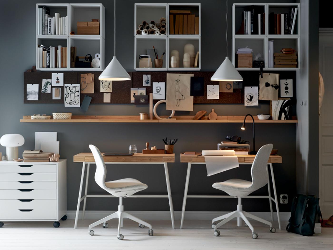 A workspace where two LÅNGFJÄLL office chairs sit at LILLÅSEN desks, with shelving, memo boards and white pendant lamps.
