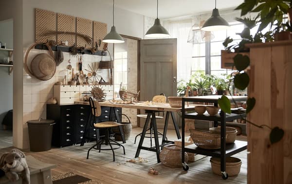 A workspace with the KULLABERG swivel chairs and desk, plenty of storage including the SKADIS wall storage and plenty of greenery.