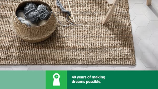 A woven rug with a basket and knitting needles and yarn in it