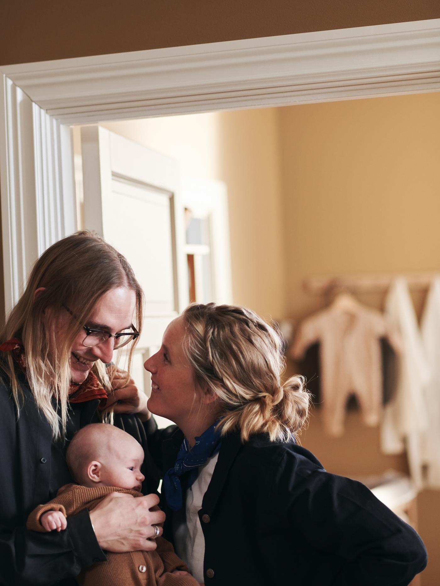 A young couple snuggles their newborn baby.