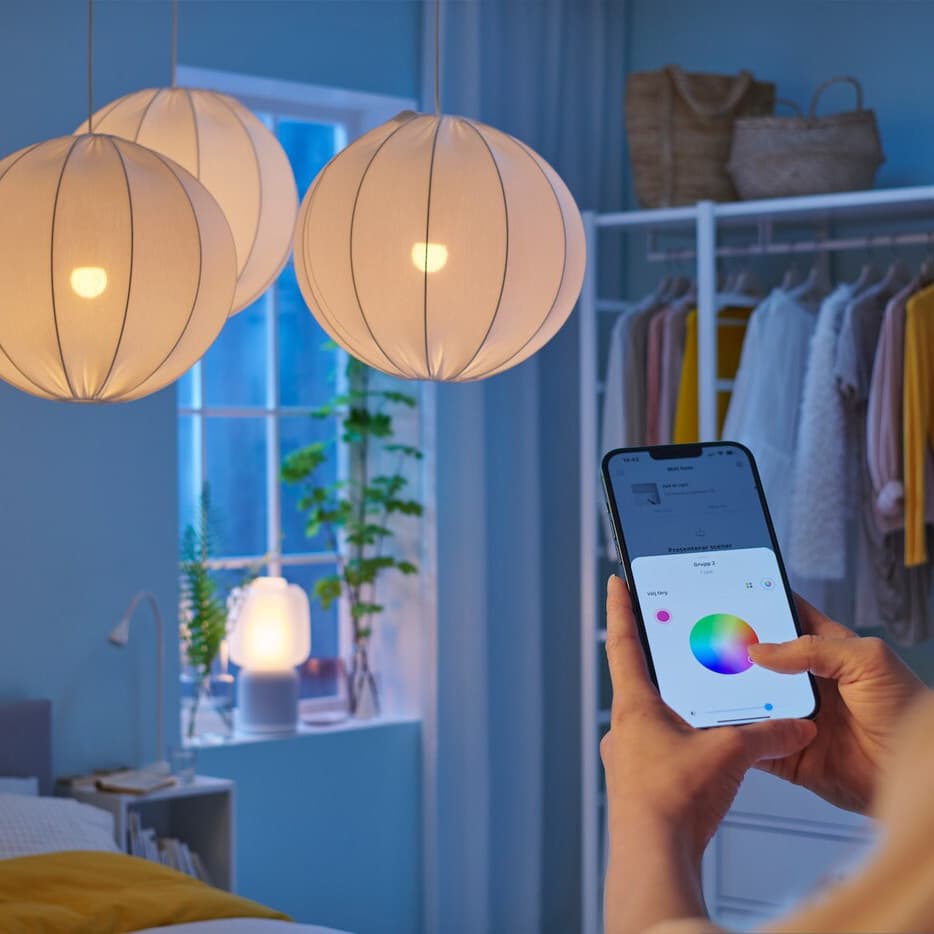 A young girl controls the colour of her bulbs using the IKEA Home Smart App