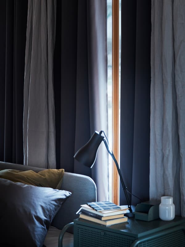 Ablak egy kék árnyalatú hálószobában, a napot szinte teljesen eltakarják a HILLEBORG függönyök.