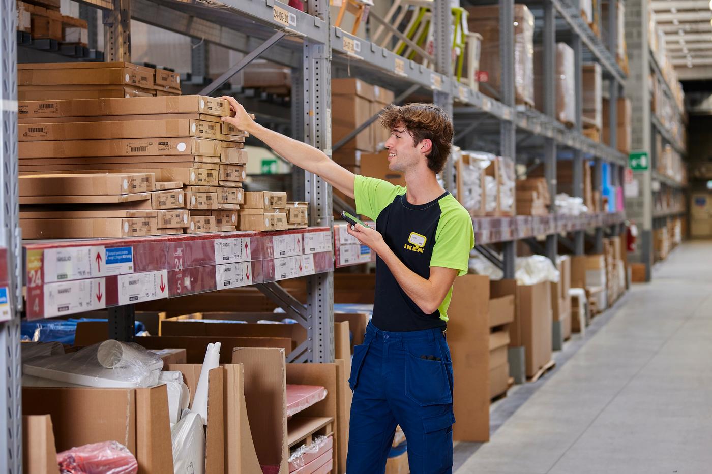 Addetto alla logistica al lavoro nel magazzino mentre prende una scatola.
