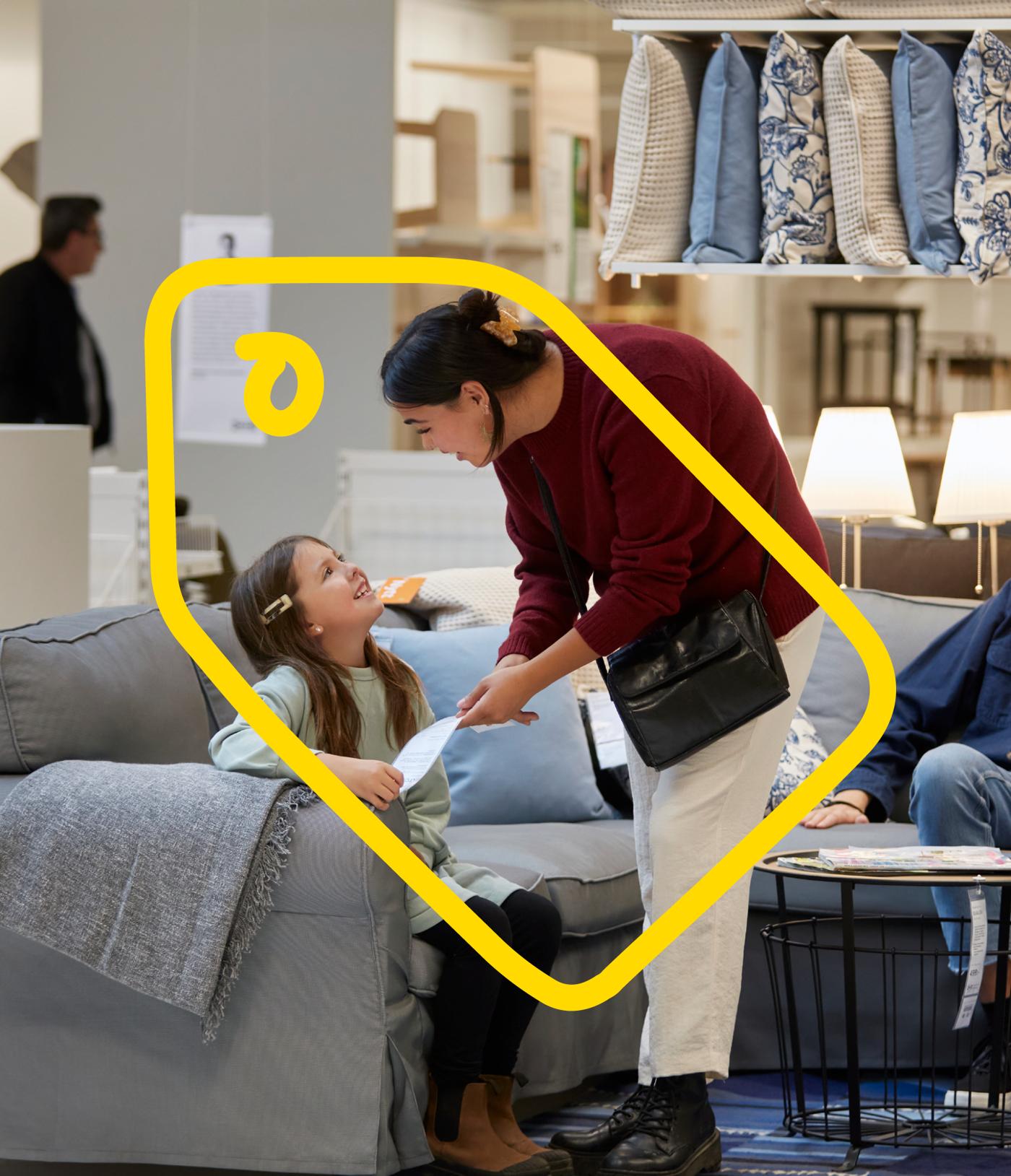 Adult and child shopping in IKEA with yellow discount line overlaid.
