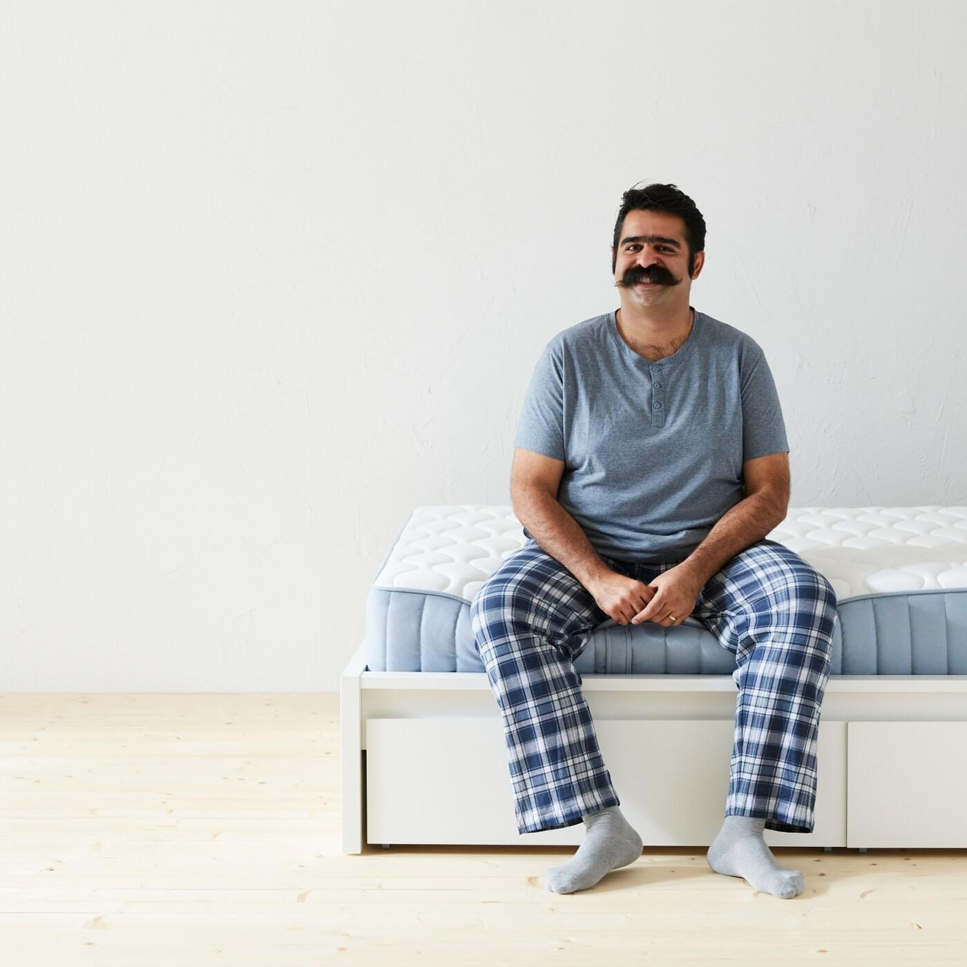 adult man sitting on bed