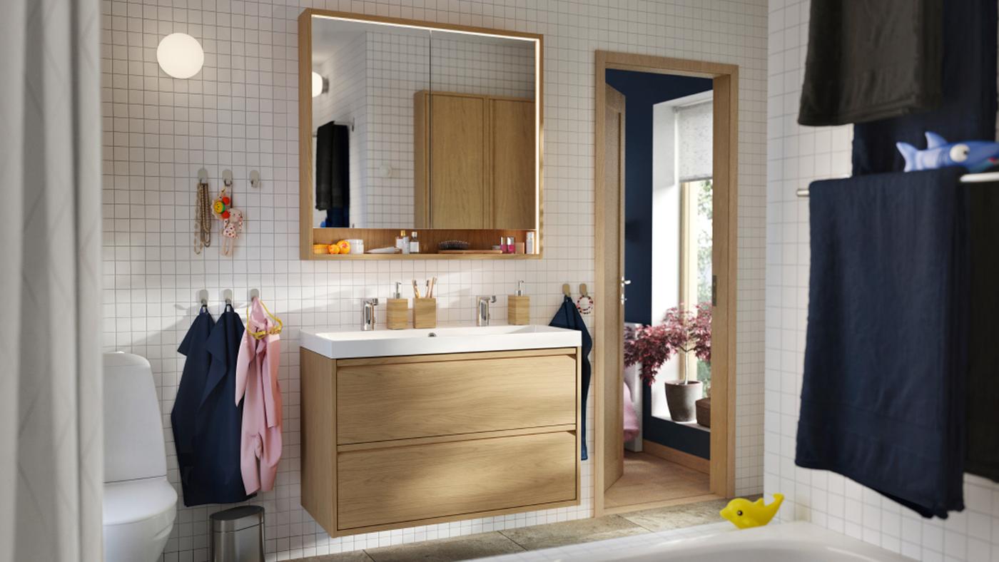 ห้องน้ำที่มีตู้อ่างล้างหน้า ÄNGSJÖN/อิงเควิน พร้อมลิ้นชักลายไม้โอ๊ค และก๊อกผสมอ่างล้างหน้าคู่ BACKSJÖN/บัคเควิน