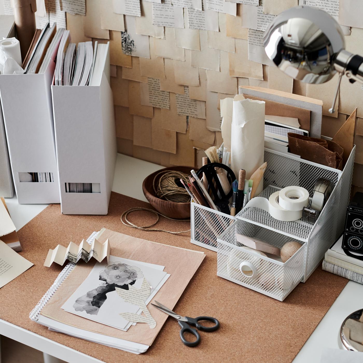 Afbeelding van een bureau met verschillende kantoorartikelen erop.