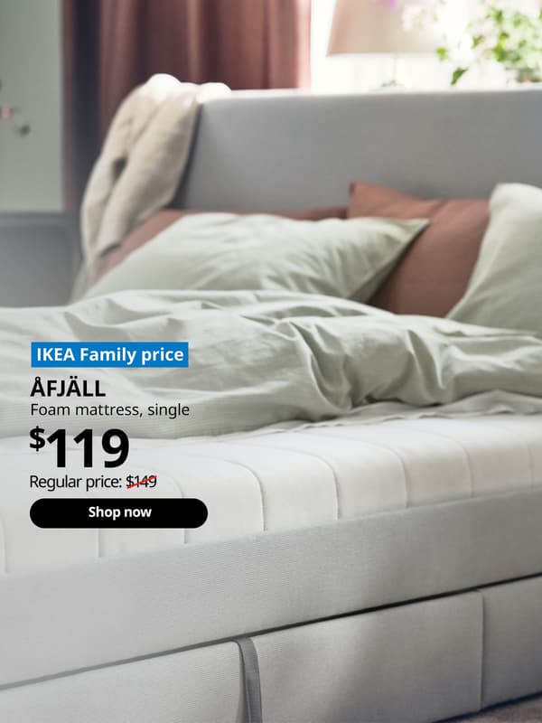 AFJALL foam mattress single size placed on a grey GLADSTAD bed with pillows and a duvet on top in pastel green and pink colours. Words on image "IKEA Family price, AFJALL, foam mattress, single, $149, Regular price: $119 with a slash, shop now". 