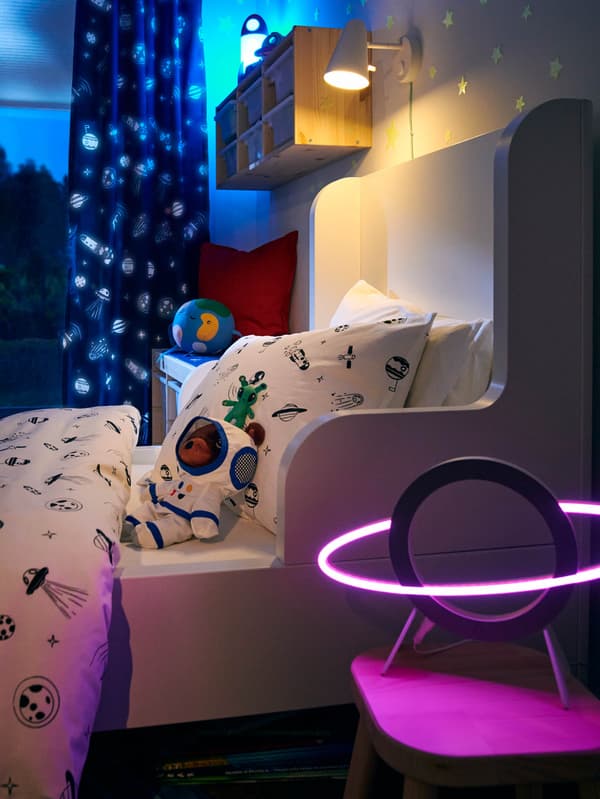 AFTONSPARV LED lámpa egy ágy előtt, melyen AFTONSPARV ágynemű látható. 