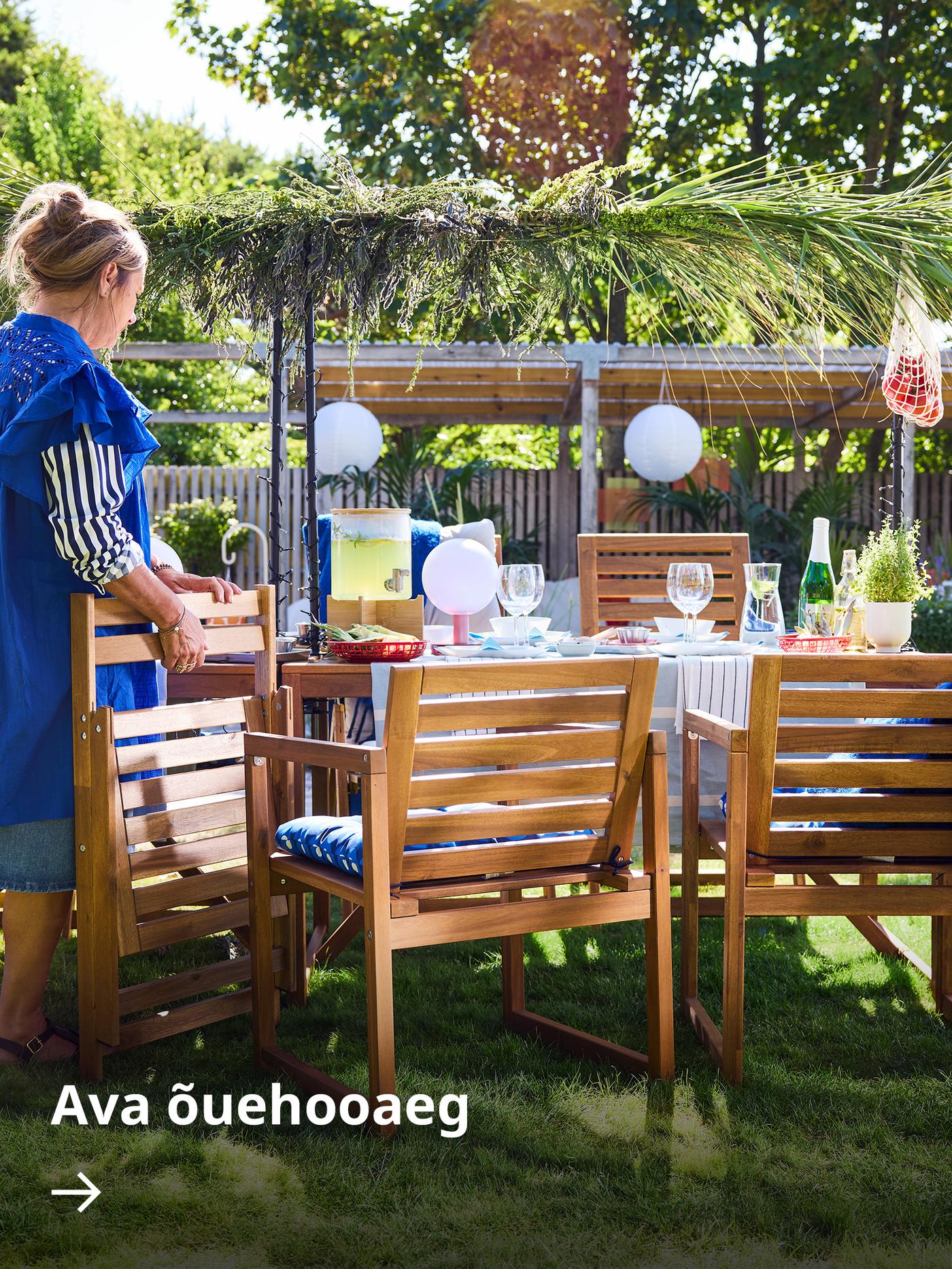 Aiavaade musta GRILLSKÄR söegrilli ja puidust NÄMMARÖ õueköögi moodulitega, mis asuvad pergolas lahtise katuse all.