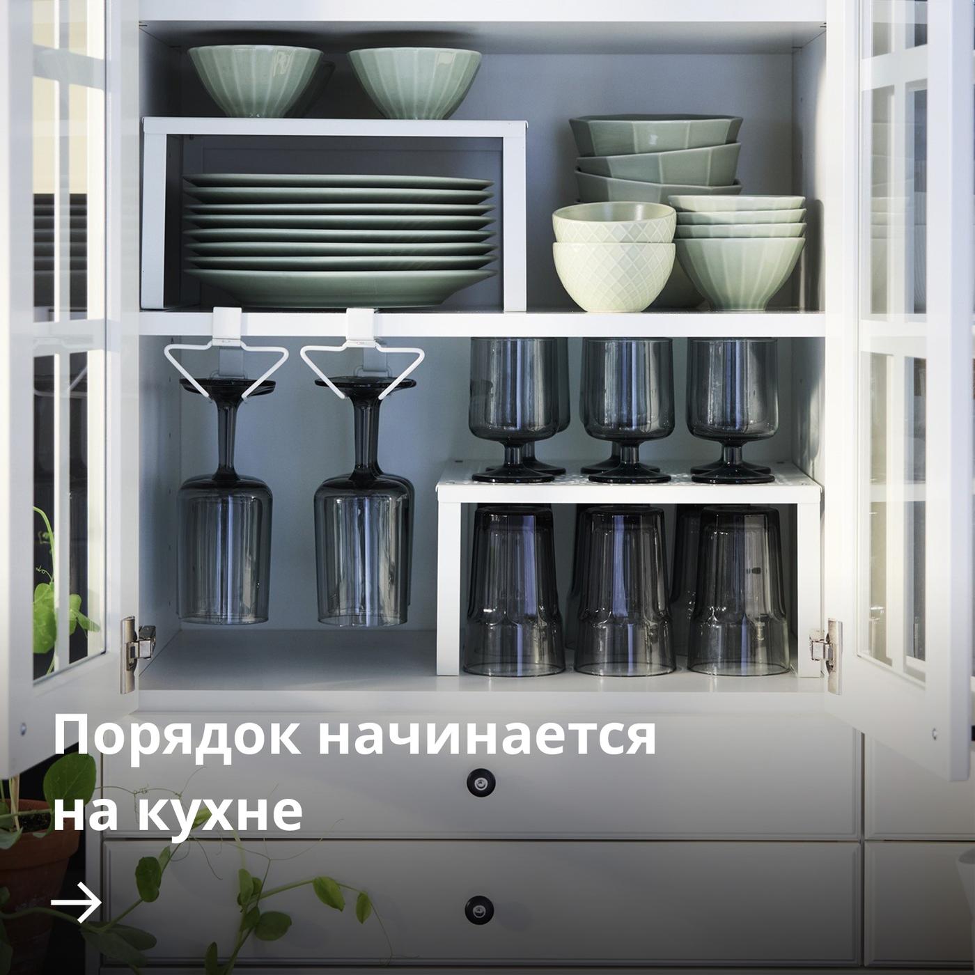 Аккуратно организованный настенный кухонный шкаф с органайзерами PÅLYCKE, в которых расставлены посуда и стаканы.