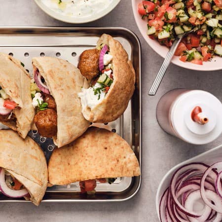Albóndegas con salsa tzatziki en pan de pita grego