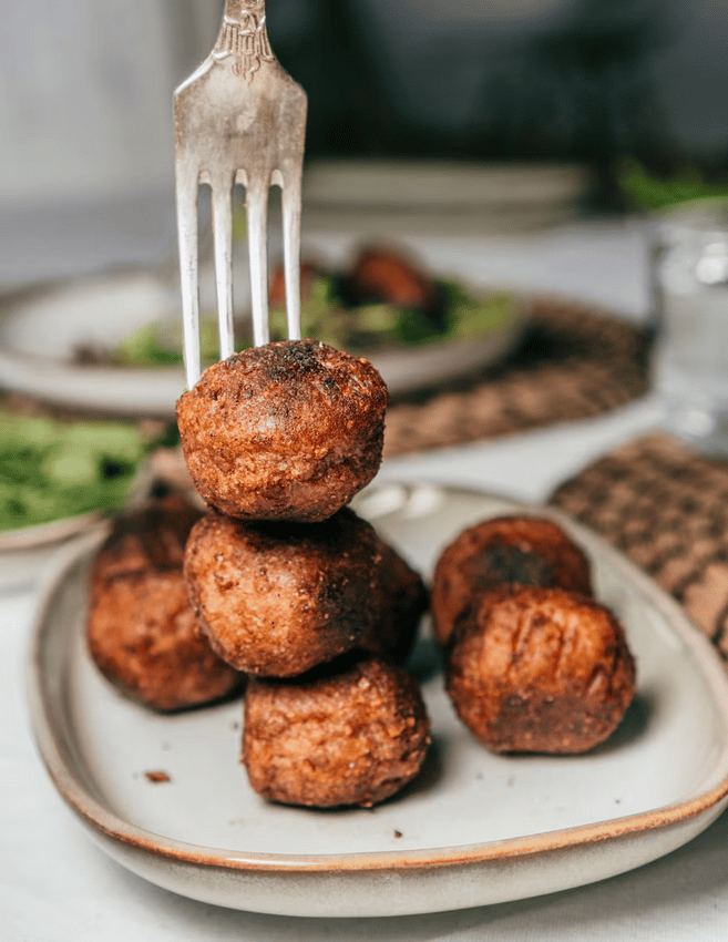 Albóndigas veganas HUVUDROLL en un plato GLADELIG de cerámica beige. 