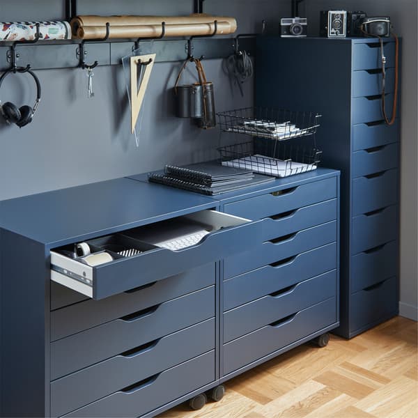 ALEX blue drawer unit on castors, one draw is open and various office supplies hanging on the rear wall. 