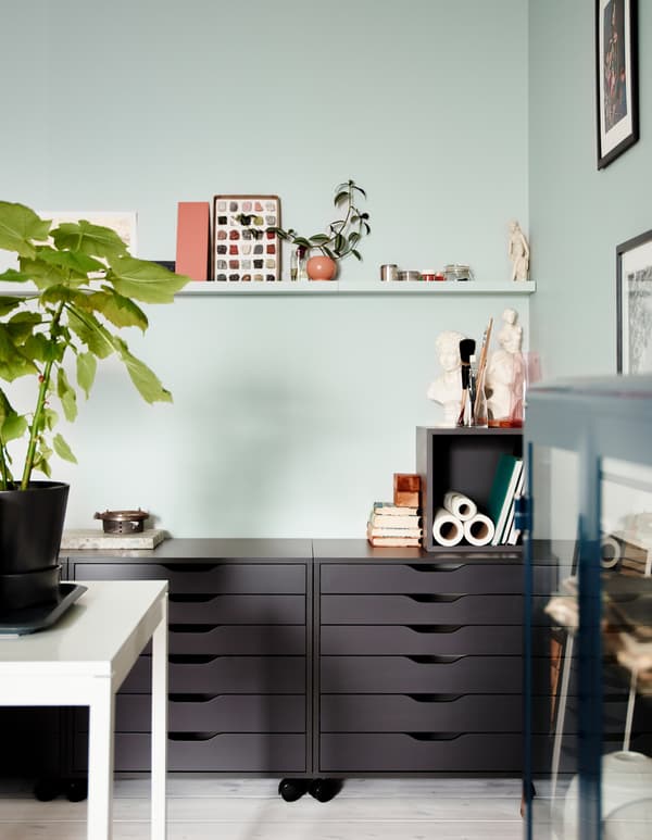 ALEX grey drawer units on castors in a living room setting, used for storing items not for show.