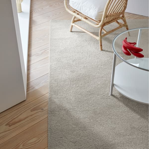 Alfombra SPORUP en color beige confeccionada con hilo fino y denso para un tacto increíblemente suave.