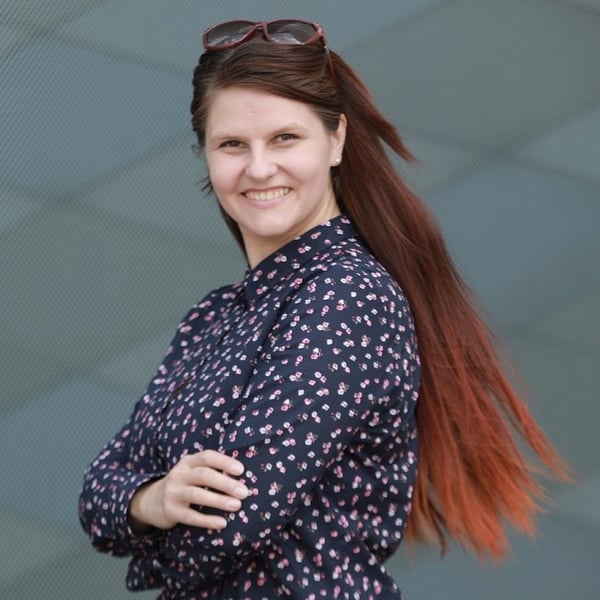 alia Karlaitė, lecturer at the Faculty of Management of Vilnius College smiling with a blue dress and red sunglasses