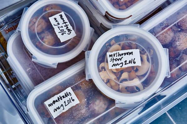Aliments rangés dans des boîtes en plastique, bacs en plastique et bocaux sur un plan de travail.