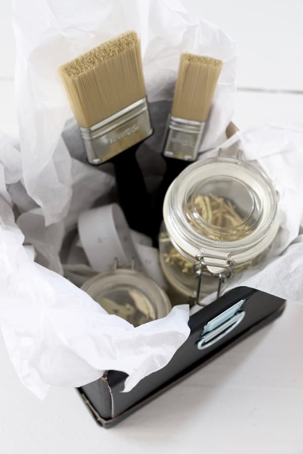 Alle Teile des Geschenks wie zum Beispiel die Gläser und die Pinsel werden in die Box gelegt. 