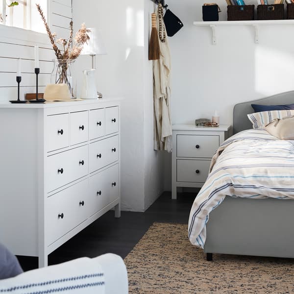 Almari berlaci 8 HEMNES yang berwarna putih ditempatkan di bawah tingkap, di sebelah katil HAUGA di dalam bilik tidur bergaya tradisional.